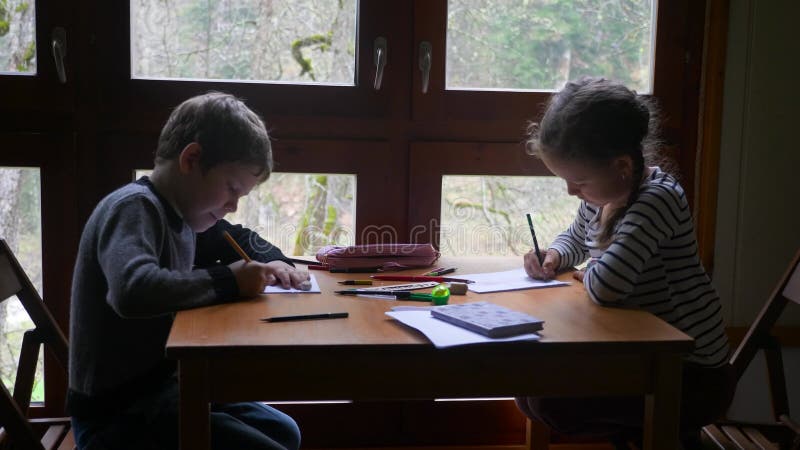 δύο παιδιά από την Κίνα σχεδιάζουν κοντά στο παράθυρο.