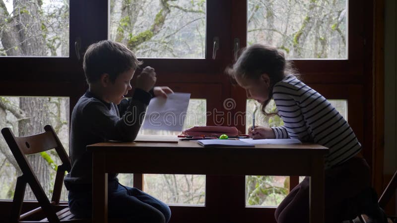 δύο παιδιά από την Κίνα σχεδιάζουν κοντά στο παράθυρο.