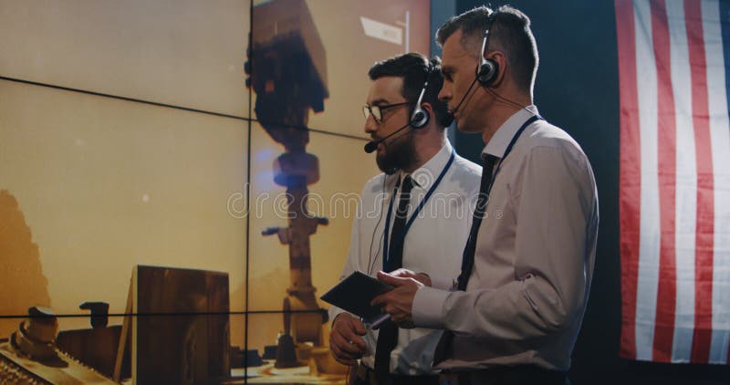 Δύο τεχνικοί που προσέχουν την οθόνη στο θάλαμο ελέγχου στοκ φωτογραφίες με δικαίωμα ελεύθερης χρήσης Δύο τεχνικοί που προσέχουν την οθόνη στο θάλαμο ελέγχου στοκ φωτογραφίες με δικαίωμα ελεύθερης χρήσης