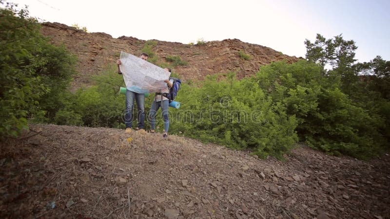 Δύο τουρίστες με τα σακίδια πλάτης που εξετάζουν το χάρτη