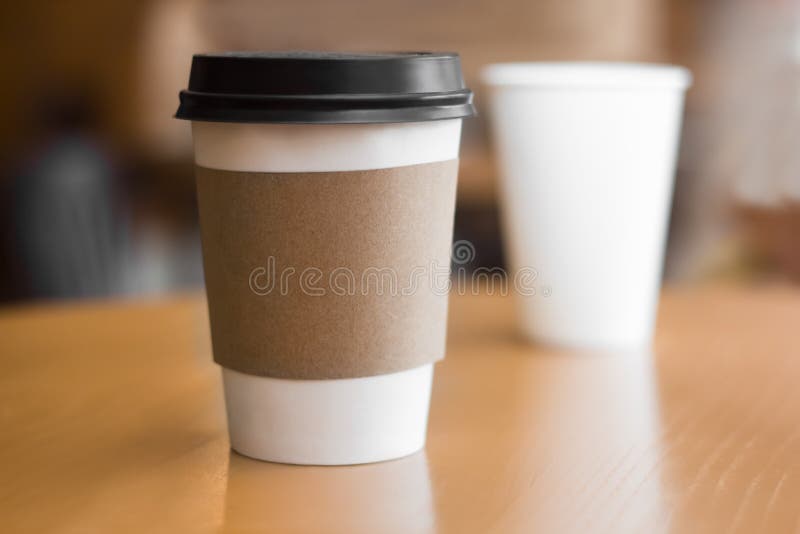 Two paper coffee cups on wooden table. Two paper coffee cups on wooden table