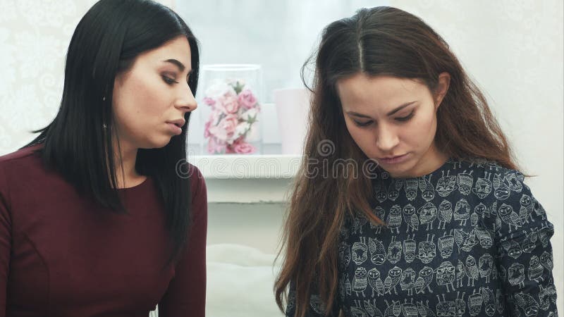 Δύο όμορφες νέες γυναίκες με το περιοδικό στην ομιλία καθιστικών απόθεμα βίντεο