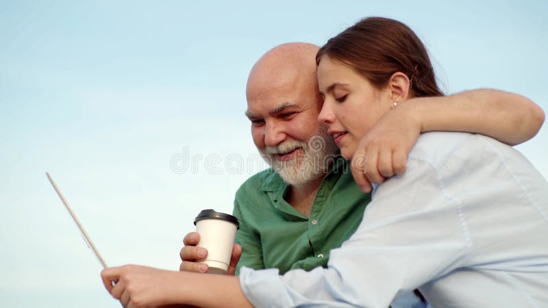 Εγγονή και νεαρή γυναίκα Κόρη χρησιμοποιούν το σημειωματάριο Εγγονή με ηλικιωμένο παππού Κόρη με