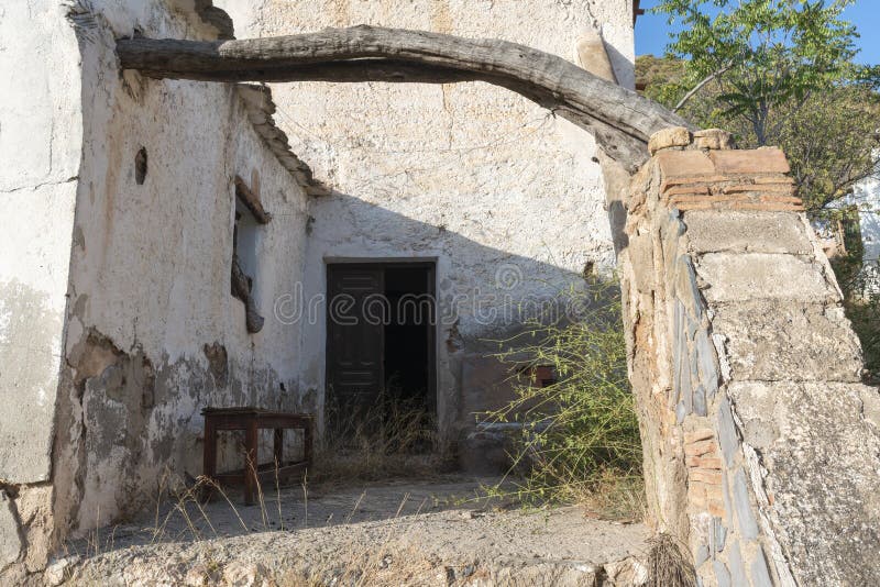 Abandoned farmhouse, the facade is white and has windows and doors, there is a wooden bench to sit on, 2 sticks cross the hall. Abandoned farmhouse, the facade is white and has windows and doors, there is a wooden bench to sit on, 2 sticks cross the hall