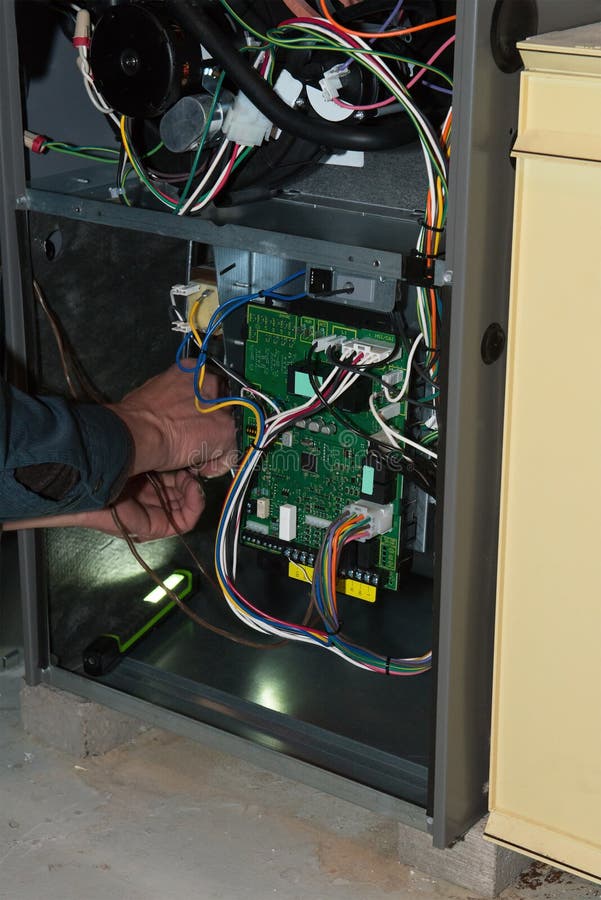 A service technician is working on a home gas furnace doing repair and maintenance. House repairs can be an expensive part of home ownership. A service technician is working on a home gas furnace doing repair and maintenance. House repairs can be an expensive part of home ownership.