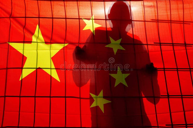 BEIJING - APR 24:Silhouette of Chinese behind fence and China flag on April 24 2009.There are about 1.5 million people in prison in China. China does not allow outsiders to inspect the penal system. BEIJING - APR 24:Silhouette of Chinese behind fence and China flag on April 24 2009.There are about 1.5 million people in prison in China. China does not allow outsiders to inspect the penal system