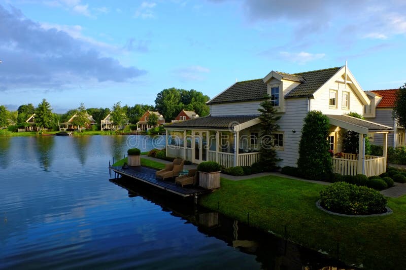 Dutch holiday homes with porch and jetty. Morning idyll in lakeside resort at summer. Dutch holiday homes with porch and jetty. Morning idyll in lakeside resort at summer.