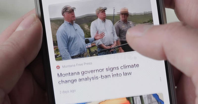 ειδήσεις κλιματικής αλλαγής σε οθόνη τηλεφώνου κύλιση στο google news app κοντά με τα δάχτυλα των χεριών.