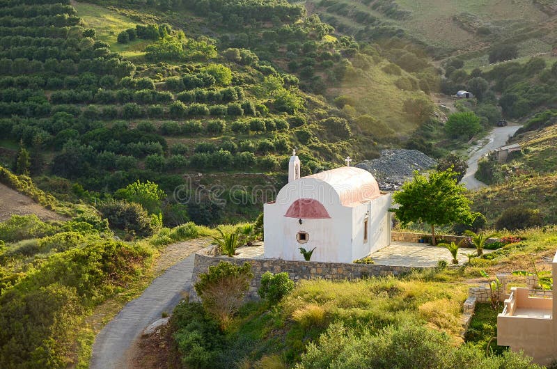 Ειδυλλιακό αγροτικό τοπίο με λόφους καλυμμένους από ελαιόδεντρα και μικροσκοπική ειρηνική ορθόδοξη εκκλησία υπό όμορφο ηλιακό φως στοκ φωτογραφία με δικαίωμα ελεύθερης χρήσης