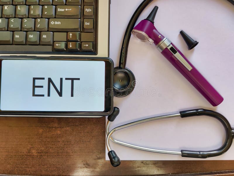 Picture of an otoscope, stethoscope, white paper, laptop and ENT written on a screen. Picture is depicting instruments used by ENT surgeon. Ear Nose Throat surgeon clinic. Picture of an otoscope, stethoscope, white paper, laptop and ENT written on a screen. Picture is depicting instruments used by ENT surgeon. Ear Nose Throat surgeon clinic