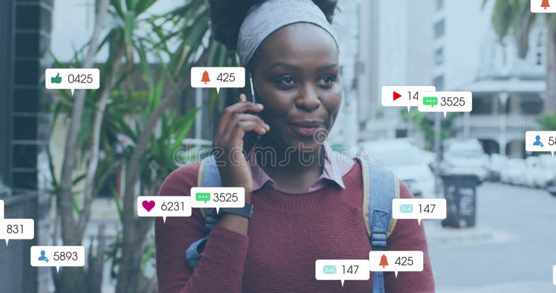 Image of multiple social media icons over african american woman talking on smartphone outdoors. Social media networking and technology concept. Image of multiple social media icons over african american woman talking on smartphone outdoors. Social media networking and technology concept