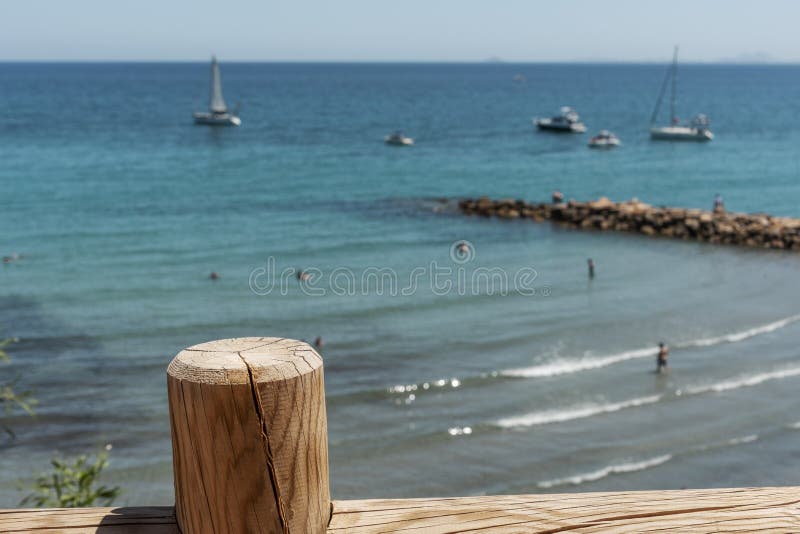 Εκλεκτική άποψη εστίασης σχετικά με τον ξύλινο φράκτη της παραλίας Cabo Roig και την ακτή Dehesa de Campoamor Επαρχία της Αλικάντ στοκ εικόνες Εκλεκτική άποψη εστίασης σχετικά με τον ξύλινο φράκτη της παραλίας Cabo Roig και την ακτή Dehesa de Campoamor Επαρχία της Αλικάντ στοκ εικόνες