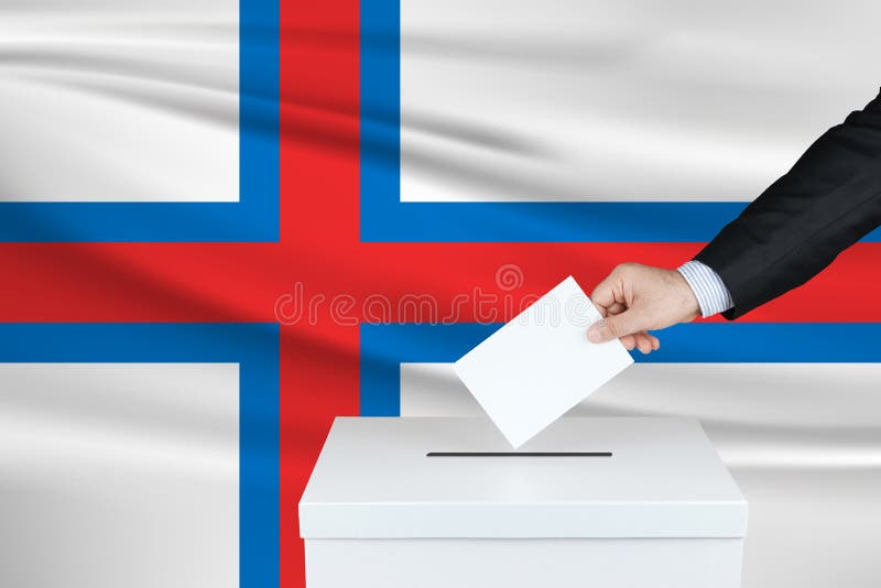 Εκλογές στις Νήσους Φερόε Το χέρι του ανθρώπου που ψηφίζει στην κάλπη Κυματιστή σημαία των Νήσων Φερόε στο παρασκήνιο στοκ φωτογραφίες με δικαίωμα ελεύθερης χρήσης Εκλογές στις Νήσους Φερόε Το χέρι του ανθρώπου που ψηφίζει στην κάλπη Κυματιστή σημαία των Νήσων Φερόε στο παρασκήνιο στοκ φωτογραφίες με δικαίωμα ελεύθερης χρήσης
