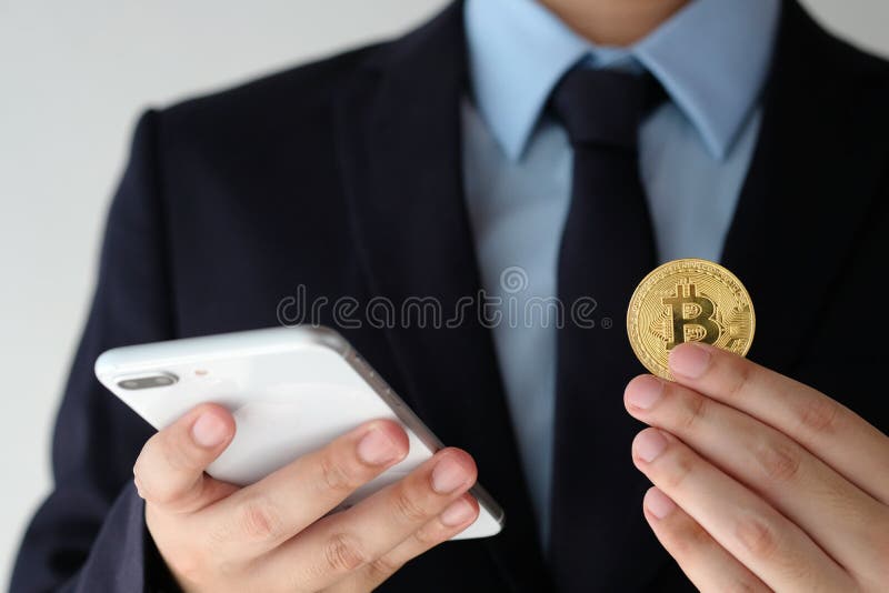 Εκμετάλλευση χεριών επιχειρηματιών bitcoin και χρησιμοποιώντας το smartphone πέρα από το λευκό στοκ φωτογραφίες Εκμετάλλευση χεριών επιχειρηματιών bitcoin και χρησιμοποιώντας το smartphone πέρα από το λευκό στοκ φωτογραφίες