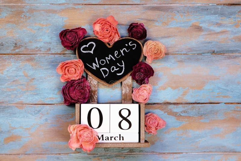 Save the date block calendar for International Womens day, March 8, with chalkboard, next to roses flowers, on wooden rustic background. Save the date block calendar for International Womens day, March 8, with chalkboard, next to roses flowers, on wooden rustic background