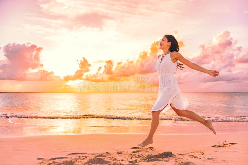 Freedom wellness well-being happiness concept. Happy carefree Asian woman feeling blissful jumping of joy on peaceful beach at sunset. Serenity, relaxation, mindfulness, stress free concepts. Freedom wellness well-being happiness concept. Happy carefree Asian woman feeling blissful jumping of joy on peaceful beach at sunset. Serenity, relaxation, mindfulness, stress free concepts.