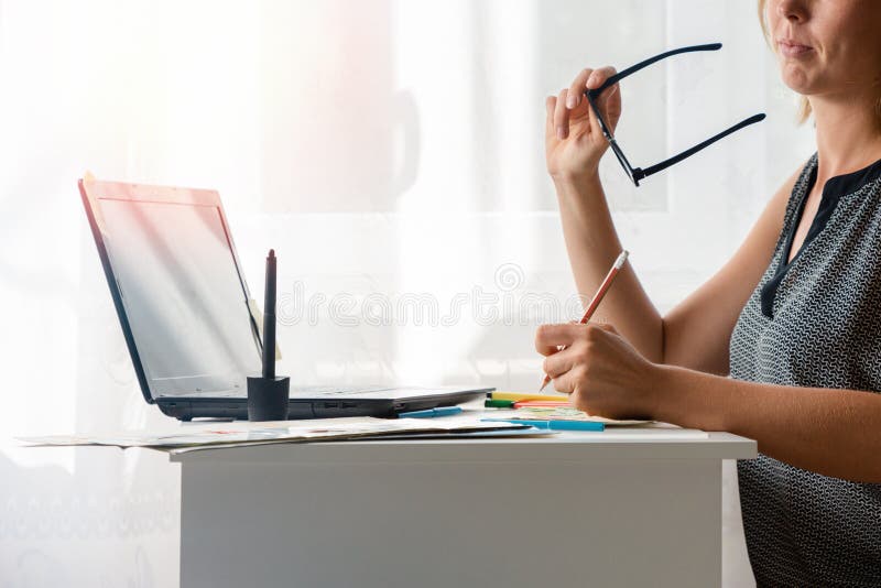 Ελεύθερη παροχή υπηρεσιών Η νεαρή γυναίκα είναι ξανθιά, κρατώντας γυαλιά και χαμογελώντας κάτι γράφει ή ζωγραφίζει Κλείσιμο στοκ εικόνα με δικαίωμα ελεύθερης χρήσης Ελεύθερη παροχή υπηρεσιών Η νεαρή γυναίκα είναι ξανθιά, κρατώντας γυαλιά και χαμογελώντας κάτι γράφει ή ζωγραφίζει Κλείσιμο στοκ εικόνα με δικαίωμα ελεύθερης χρήσης