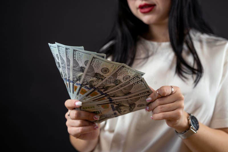 ελκυστική νεαρή γυναίκα από τον καύκασο που κρατά λεφτά απομονωμένα από μαύρους στοκ εικόνα με δικαίωμα ελεύθερης χρήσης