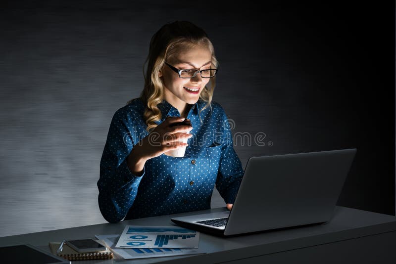 Ελκυστική ξανθή εργασία στο lap-top στο σκοτεινό γραφείο Μικτά μέσα στοκ εικόνα Ελκυστική ξανθή εργασία στο lap-top στο σκοτεινό γραφείο Μικτά μέσα στοκ εικόνα