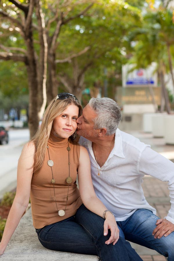 Attractive middle age couple posing along Miami's Brickell Avenue in the late afternoon with trees and street in the background. Attractive middle age couple posing along Miami's Brickell Avenue in the late afternoon with trees and street in the background.