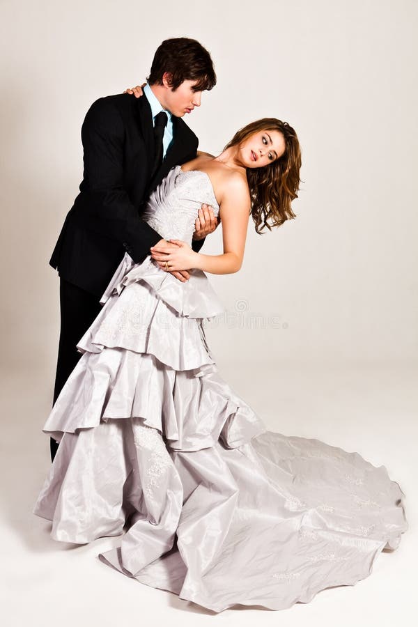 An attractive young couple in the midst of a dance move are dressed in formal attire. Vertical shot. An attractive young couple in the midst of a dance move are dressed in formal attire. Vertical shot.