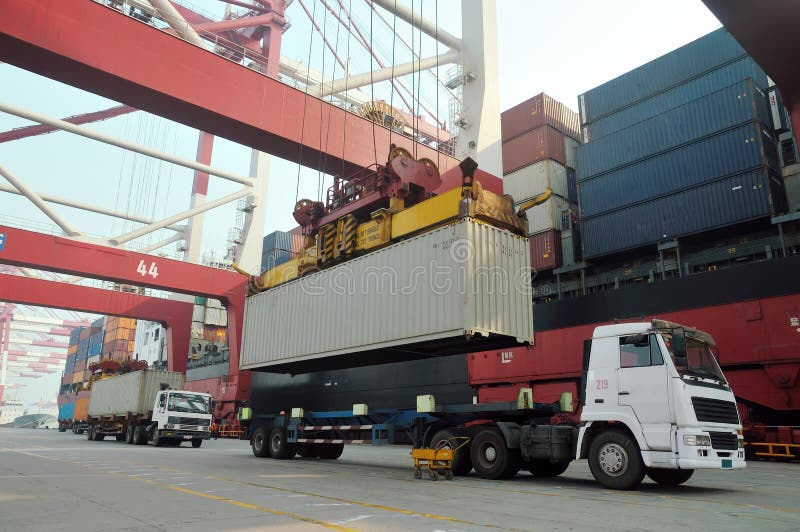 Crane is loading and unloading containers from truck to ship. Crane is loading and unloading containers from truck to ship