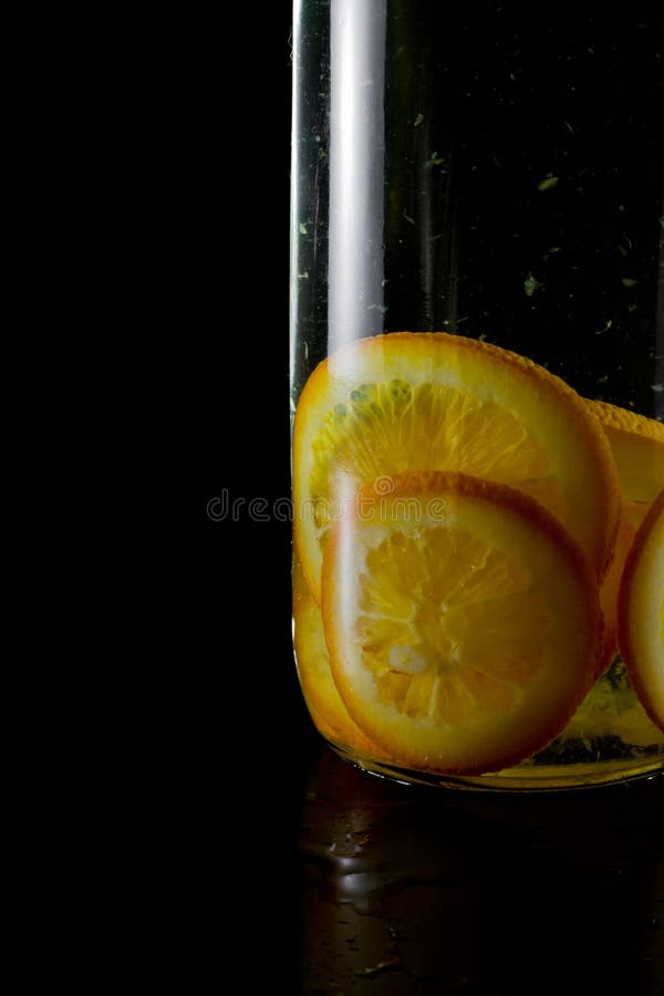 Orange infused vodka bottle on a dark black background. Orange infused vodka bottle on a dark black background