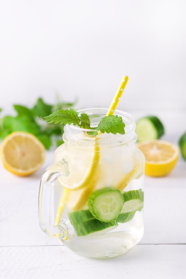 Infused Water With Lemon Cucumber and Mint on Wooden Background Detox Water Vertical Lemonad. Infused Water With Lemon Cucumber and Mint on Wooden Background Detox Water Vertical Lemonad.