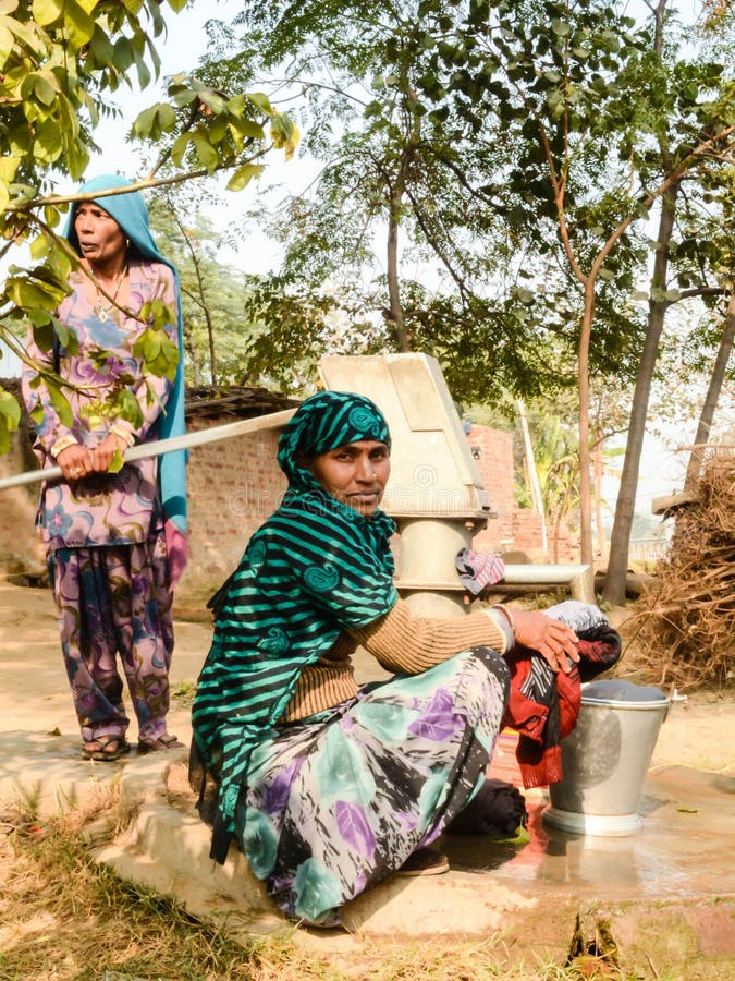 Village ladies washing clothes using hand pump. Village ladies washing clothes using hand pump