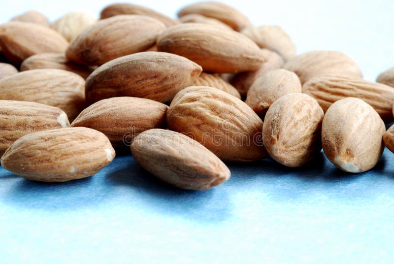 Pile of almonds against a blue background #1. Pile of almonds against a blue background #1