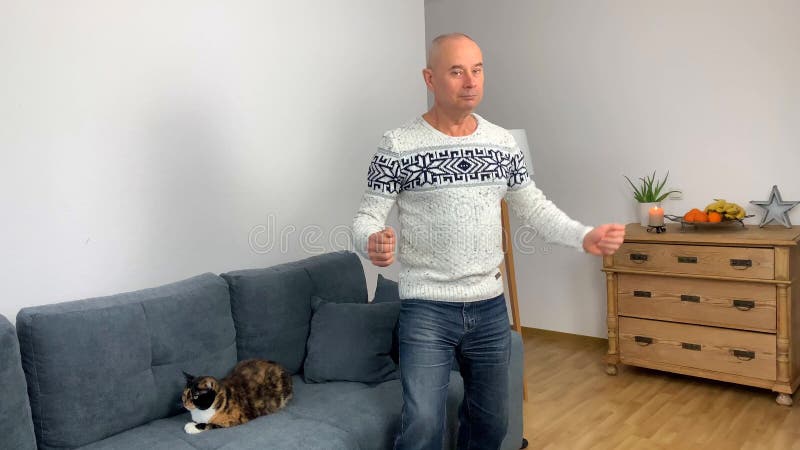 ενήλικας με σκανδιναβικό λευκό πουλόβερ χορεύει διασκέδαση στο σπίτι ιδέα της καλής διάθεσης