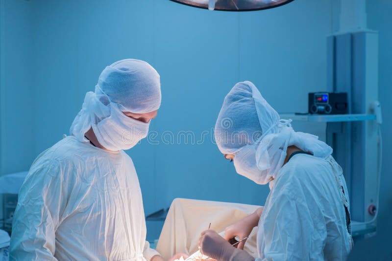 Ενήλικας χειρουργός διδάσκει σε ένα νεαρό γιατρό ένα κορίτσι Πρακτική άσκηση Ένα κορίτσι χειρουργός βοηθά κατά τη διάρκεια μιας ο στοκ φωτογραφίες με δικαίωμα ελεύθερης χρήσης Ενήλικας χειρουργός διδάσκει σε ένα νεαρό γιατρό ένα κορίτσι Πρακτική άσκηση Ένα κορίτσι χειρουργός βοηθά κατά τη διάρκεια μιας ο στοκ φωτογραφίες με δικαίωμα ελεύθερης χρήσης