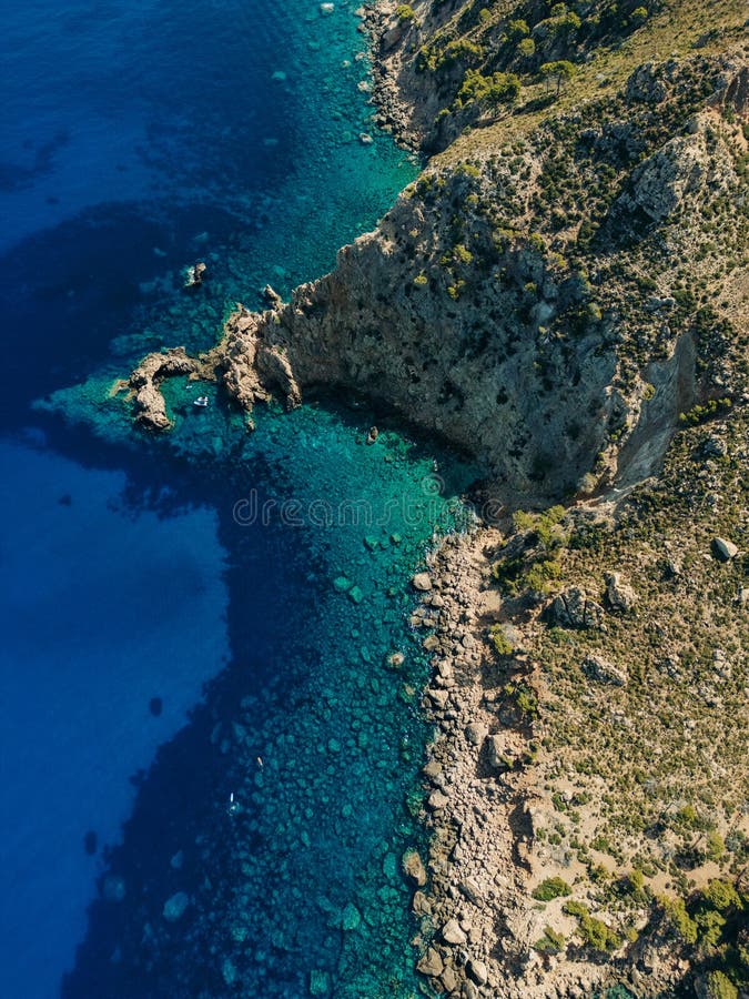 εναέρια άποψη βραχώδους ακτογραμμής με καθαρά τυρκουάζ ύδατα και ανθεκτικούς βράχους απεικόνιση αποθεμάτων