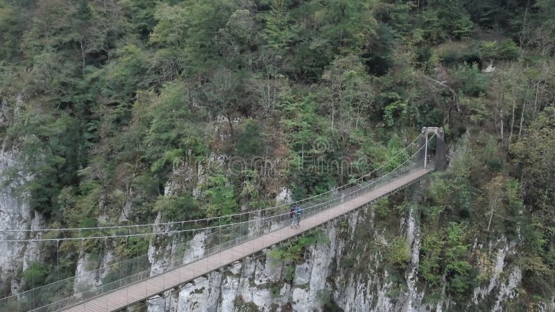 εναέρια άποψη ενός αγαπημένου ζευγαριού που διασχίζει μια επικίνδυνη γέφυρα