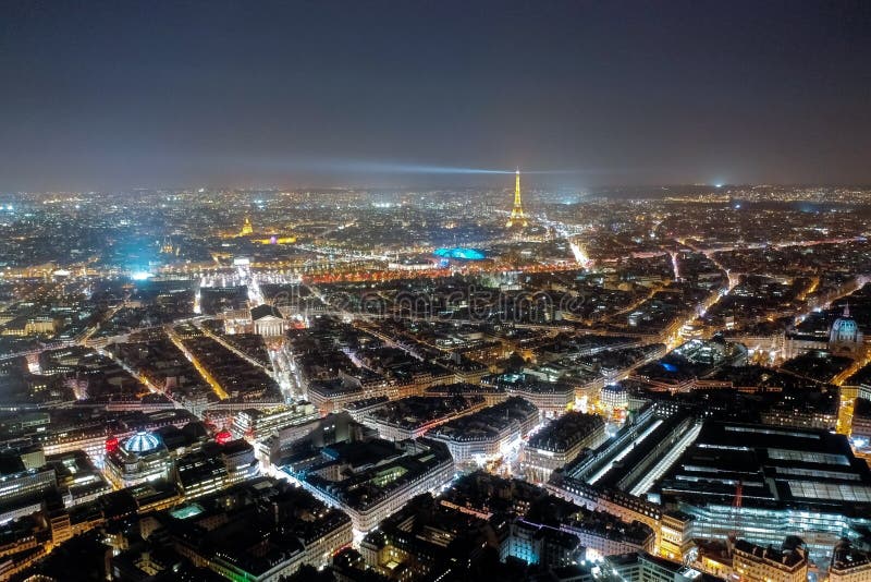 Paris Aerial View Cityscape at Night in France. Beautiful City Skyline and Famous Landmarks, Illuminated with Light in Dark Evening Time. French Capital is a popular European Tourist Destination. Paris Aerial View Cityscape at Night in France. Beautiful City Skyline and Famous Landmarks, Illuminated with Light in Dark Evening Time. French Capital is a popular European Tourist Destination