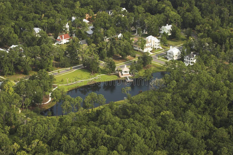 Aerial view of wooded neighborhood with pond. Aerial view of wooded neighborhood with pond