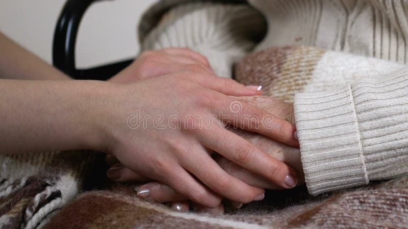 Ενθαρρυντική εγγονή που κρατά το ηλικιωμένο γυναικείο χέρι tenderly, που αγαπά τις σχέσεις