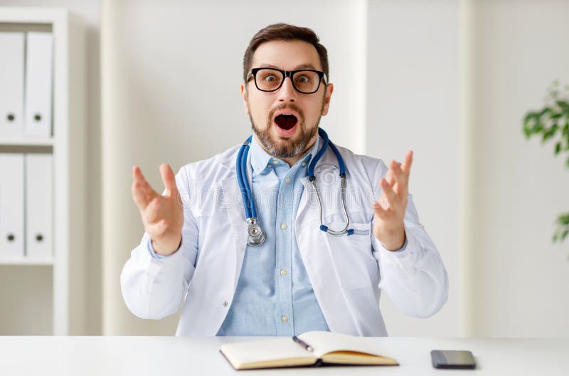 Happy male doctor in uniform and glasses smiling and gesticulating while speaking with patient through video chat app. Happy male doctor in uniform and glasses smiling and gesticulating while speaking with patient through video chat app