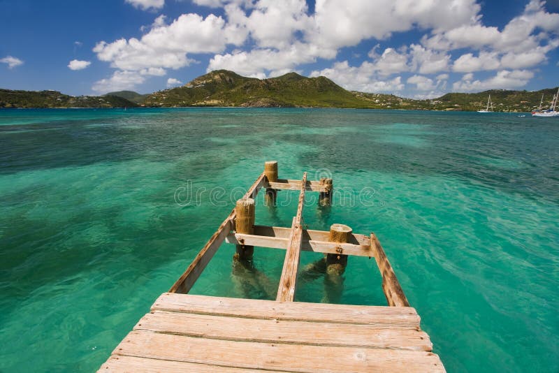 Damaged dock over turquoise waters on tropical island. Damaged dock over turquoise waters on tropical island