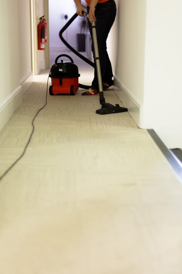 Επαγγελματική καθαρίζοντας υπηρεσία Hoovering τάπητας γυναικών στην αρχή στοκ φωτογραφίες Επαγγελματική καθαρίζοντας υπηρεσία Hoovering τάπητας γυναικών στην αρχή στοκ φωτογραφίες