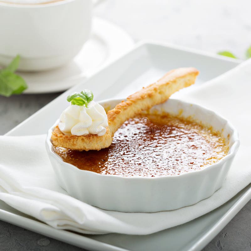 Επιδόρπιο creme brulle με ένα φλυτζάνι του cappuccino στοκ εικόνα Επιδόρπιο creme brulle με ένα φλυτζάνι του cappuccino στοκ εικόνα