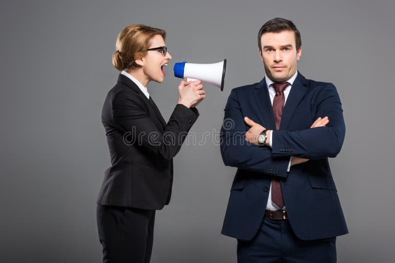 επιθετική επιχειρηματίας με το bullhorn που φωνάζει στον επιχειρηματία στοκ εικόνες