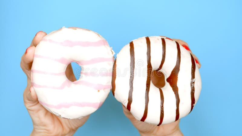 Επιλογή έννοιας μεταξύ doughnut σοκολάτας και doughnut φραουλών τα θηλυκά χέρια με την κόκκινη στιλβωτική ουσία καρφιών κρατούν ρ στοκ φωτογραφία με δικαίωμα ελεύθερης χρήσης Επιλογή έννοιας μεταξύ doughnut σοκολάτας και doughnut φραουλών τα θηλυκά χέρια με την κόκκινη στιλβωτική ουσία καρφιών κρατούν ρ στοκ φωτογραφία με δικαίωμα ελεύθερης χρήσης