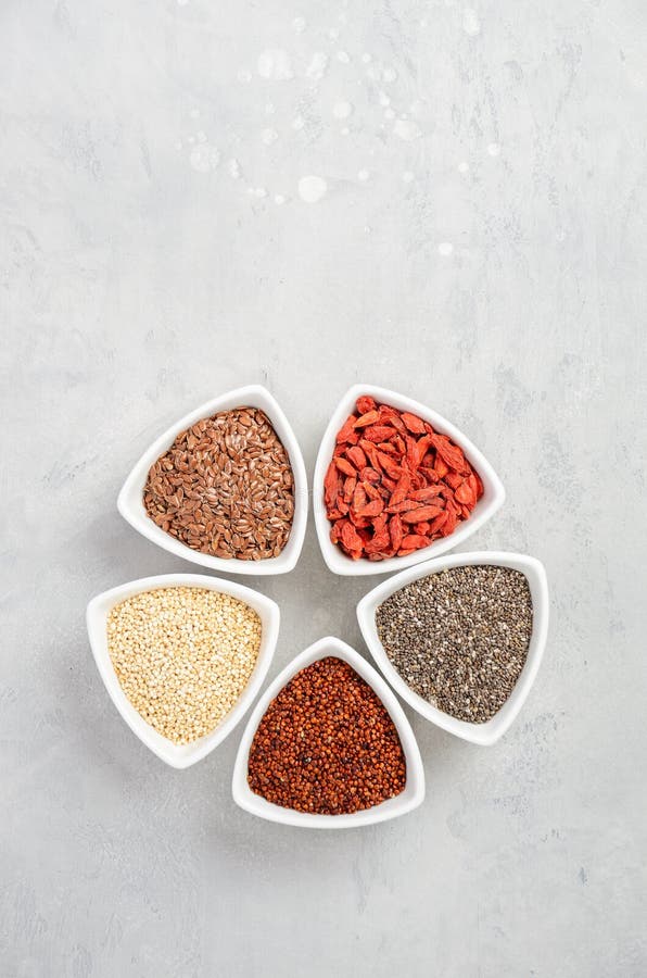 Επιλογή των superfoods στα άσπρα κύπελλα στο γκρίζο συγκεκριμένο υπόβαθρο Quinoa, chia, μούρο goji και σπόροι λιναριού στοκ εικόνα Επιλογή των superfoods στα άσπρα κύπελλα στο γκρίζο συγκεκριμένο υπόβαθρο Quinoa, chia, μούρο goji και σπόροι λιναριού στοκ εικόνα
