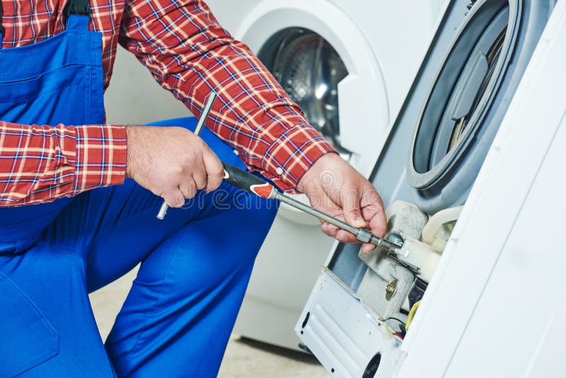 Washing machine repair. Repairer hands with screwdriver disassembling damaged unit for repair. Washing machine repair. Repairer hands with screwdriver disassembling damaged unit for repair