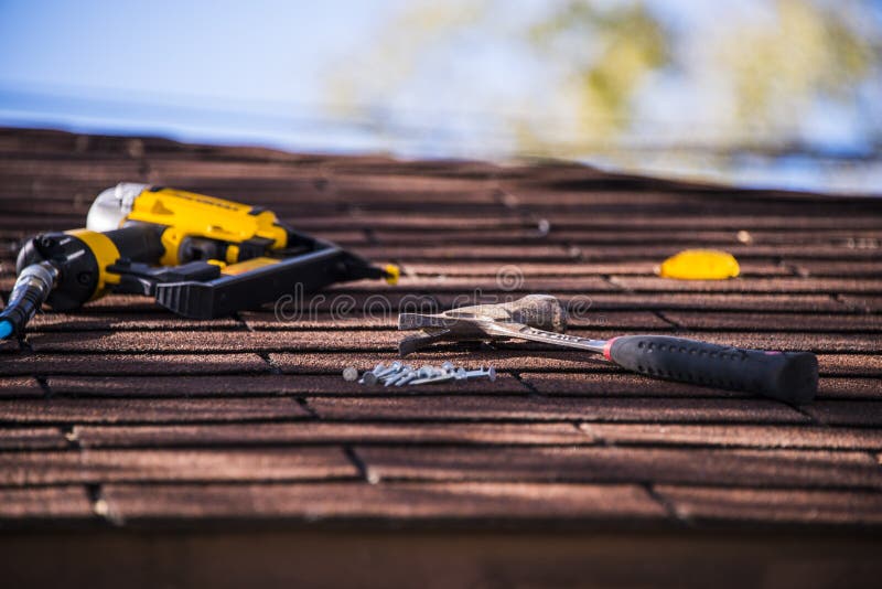 Roof shingle repair with nail gun and hummer. Roof shingle repair with nail gun and hummer