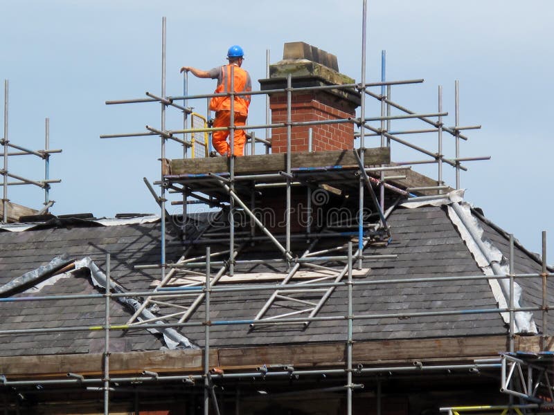 Roof and chimney repair work being done on a home in a residential neighbourhood in Yorkshire, England. Roof and chimney repair work being done on a home in a residential neighbourhood in Yorkshire, England.