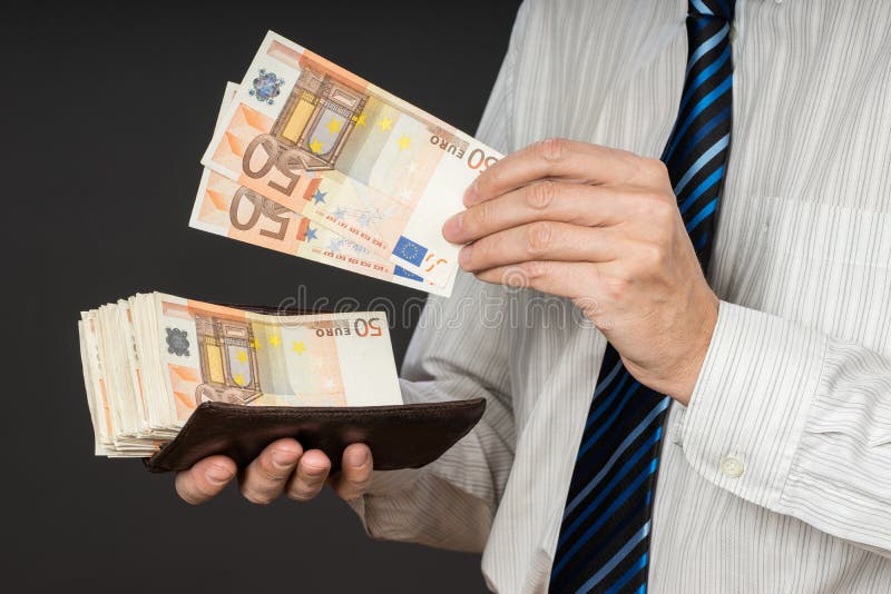 Επιχειρηματίας που βάζει τα τραπεζογραμμάτια στο πορτοφόλι του Σωρός των χρημάτων πενήντα ευρώ Το επιχειρησιακό άτομο κρατά τα με στοκ φωτογραφία με δικαίωμα ελεύθερης χρήσης Επιχειρηματίας που βάζει τα τραπεζογραμμάτια στο πορτοφόλι του Σωρός των χρημάτων πενήντα ευρώ Το επιχειρησιακό άτομο κρατά τα με στοκ φωτογραφία με δικαίωμα ελεύθερης χρήσης