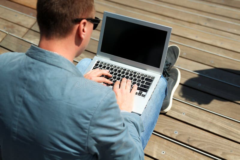 Επιχειρηματίας που εργάζεται με ένα lap-top, που κάθεται έξω στοκ εικόνες Επιχειρηματίας που εργάζεται με ένα lap-top, που κάθεται έξω στοκ εικόνες