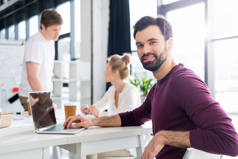 Επιχειρηματίας που εργάζεται με το lap-top στον εργασιακό χώρο στην αρχή, συνάδελφοι πίσω στοκ φωτογραφία με δικαίωμα ελεύθερης χρήσης Επιχειρηματίας που εργάζεται με το lap-top στον εργασιακό χώρο στην αρχή, συνάδελφοι πίσω στοκ φωτογραφία με δικαίωμα ελεύθερης χρήσης